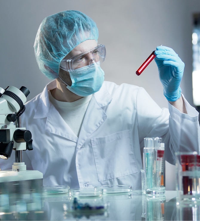 Pipette dripping a solution into test tubes with a cell image in the background.